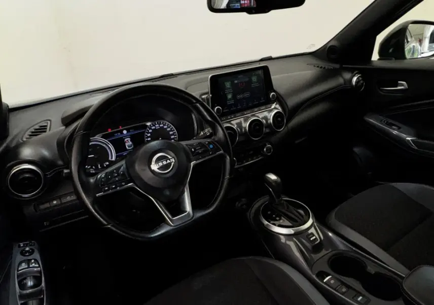 Vue intérieure côté conducteur du Nissan Juke Hybrid 143 Business+ 2023, tableau de bord noir avec écran tactile central.