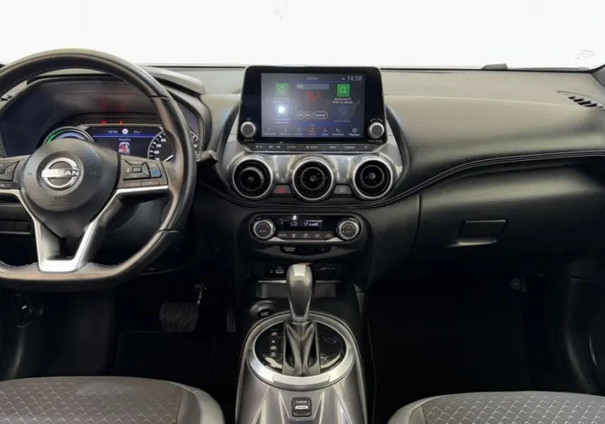Vue intérieure frontale du tableau de bord noir du Nissan Juke Hybrid 143 Business+ avec écran tactile et volant cuir.