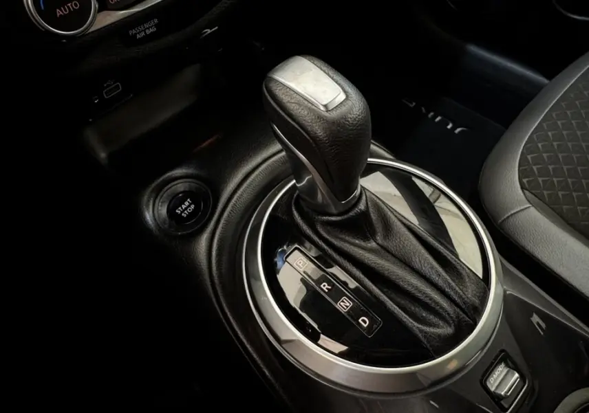 Gros plan sur la commande de boîte automatique et bouton start/stop du Nissan Juke Hybrid 2023, intérieur noir.