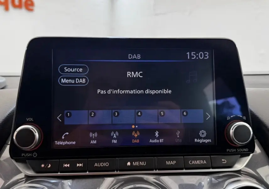 Écran tactile central du Nissan Juke Hybrid 143 Business+ 2023 affichant la radio DAB, vue intérieure frontale.
