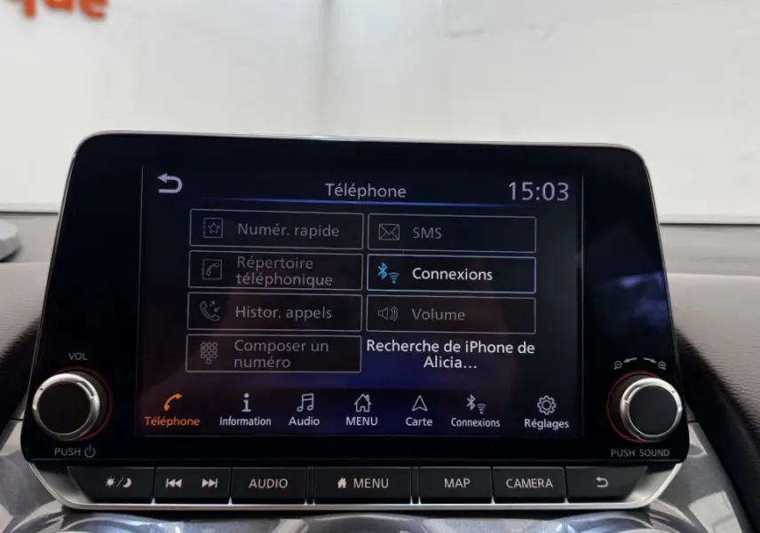 Écran tactile central du tableau de bord du Nissan Juke Hybrid 143 Business+ gris foncé, affichant le menu téléphone.
