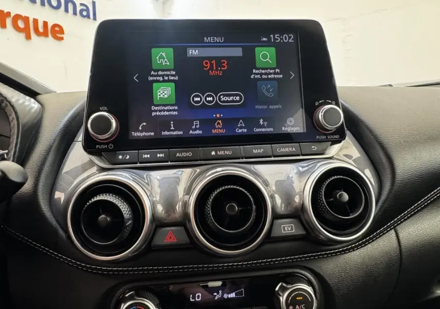 Tableau de bord du Nissan Juke Hybrid 143 Business+ 2023, avec écran tactile central et aérateurs ronds chromés.