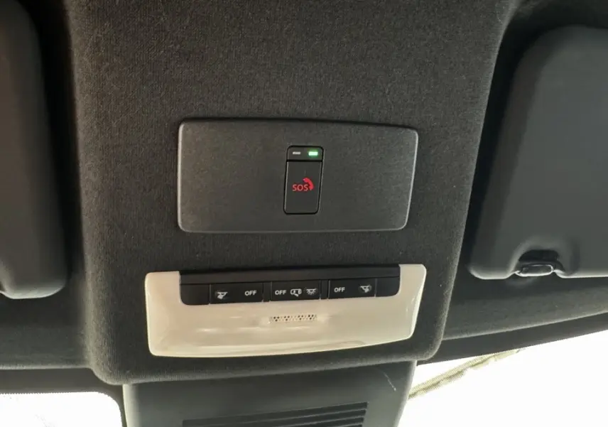 Vue intérieure du plafond du Nissan Juke Hybrid 143 Business+ 2023, montrant le bouton SOS et commandes d'éclairage.
