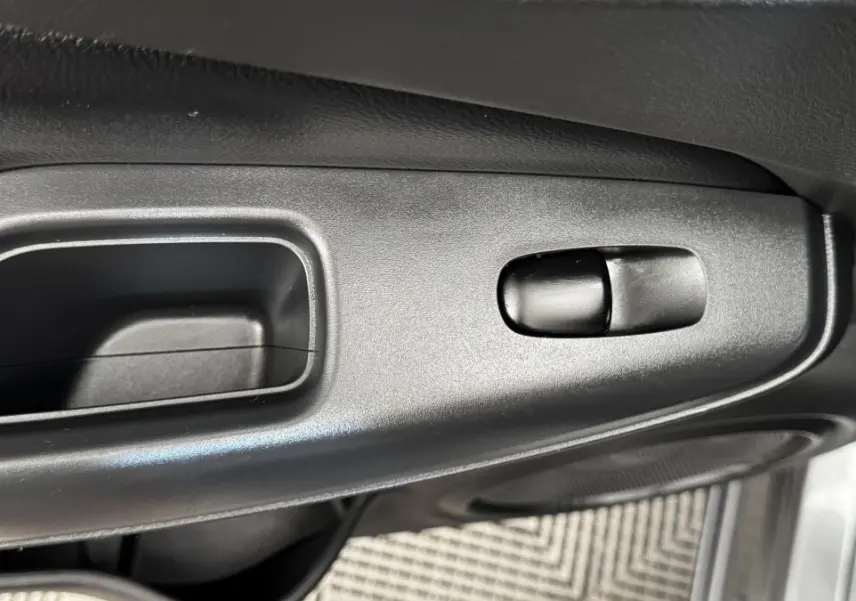 Détail de la poignée intérieure de porte côté conducteur du Nissan Juke Hybrid 143 Business+ gris foncé 2023.