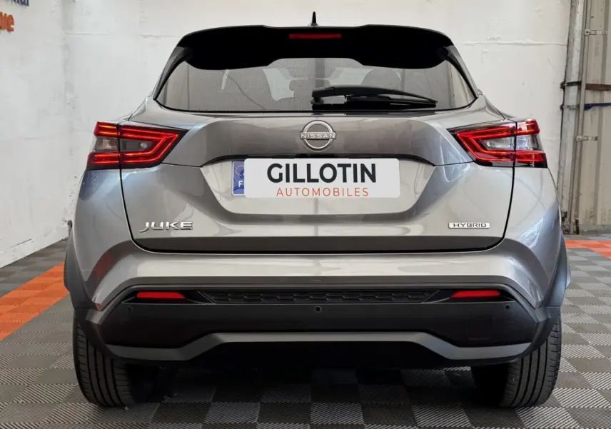 Vue arrière du Nissan Juke Hybrid gris foncé avec feux LED distinctifs et logo Hybrid visible sur le coffre.