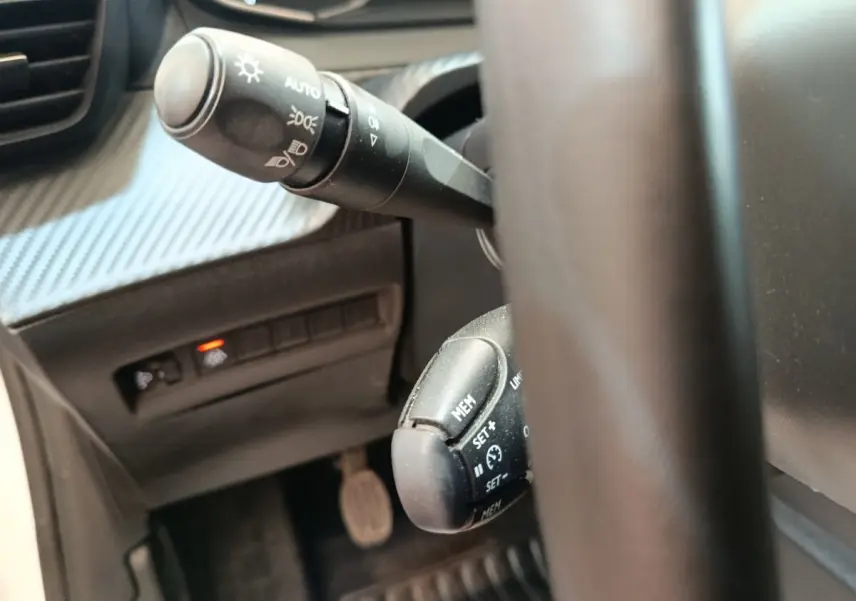 Gros plan sur le volant cuir et les commandes multifonctions de la Peugeot 208 1.5 BlueHDi 100 S&S Premium 2023.
