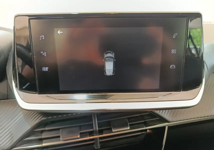 Écran tactile central affichant une vue aérienne du véhicule dans l'habitacle d'une Peugeot 208 blanche.