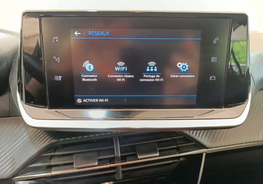 Écran tactile central de la Peugeot 208 1.5 BlueHDi 100 S&S Premium 2023 affichant les options de connexion Wi-Fi et Bluetooth.