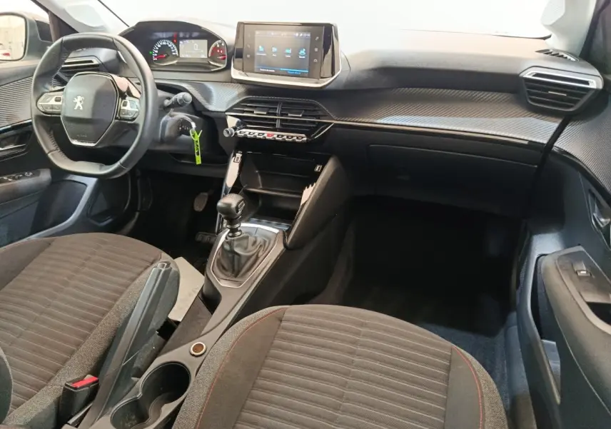 Intérieur de la Peugeot 208 1.5 BlueHDi 2023, vue de face côté conducteur, volant cuir et écran tactile central.