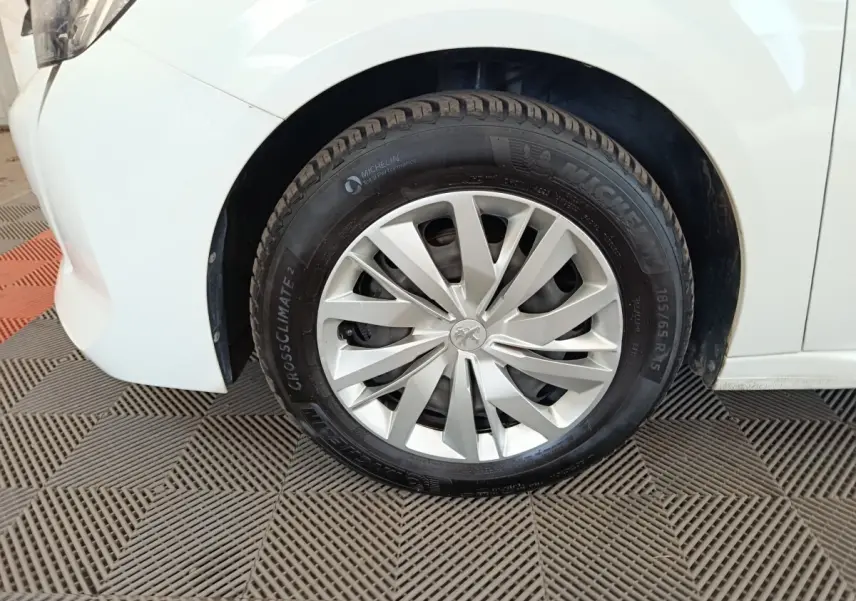 Gros plan sur la roue avant gauche blanche d'une Peugeot 208 1.5 BlueHDi 100 S&S Premium 2023.