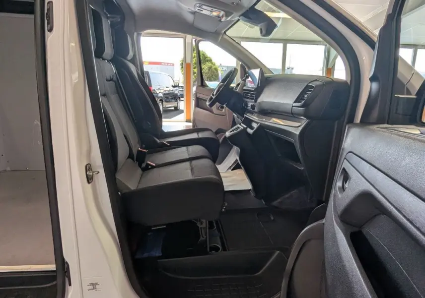Vue intérieure côté conducteur du Fiat Scudo Fourgon blanc 2025, montrant les sièges avant et le tableau de bord moderne.
