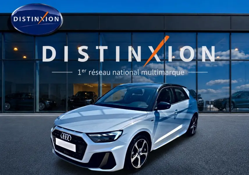 Audi A1 Sportback blanc toit noir vue 3/4 avant droit avec jantes alliage et calandre noire devant showroom Distinxion.