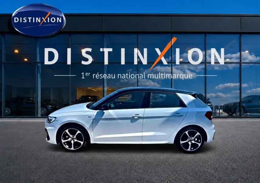 Audi A1 Sportback blanc et noir vue de profil côté gauche devant une vitrine avec logo Distinxion.