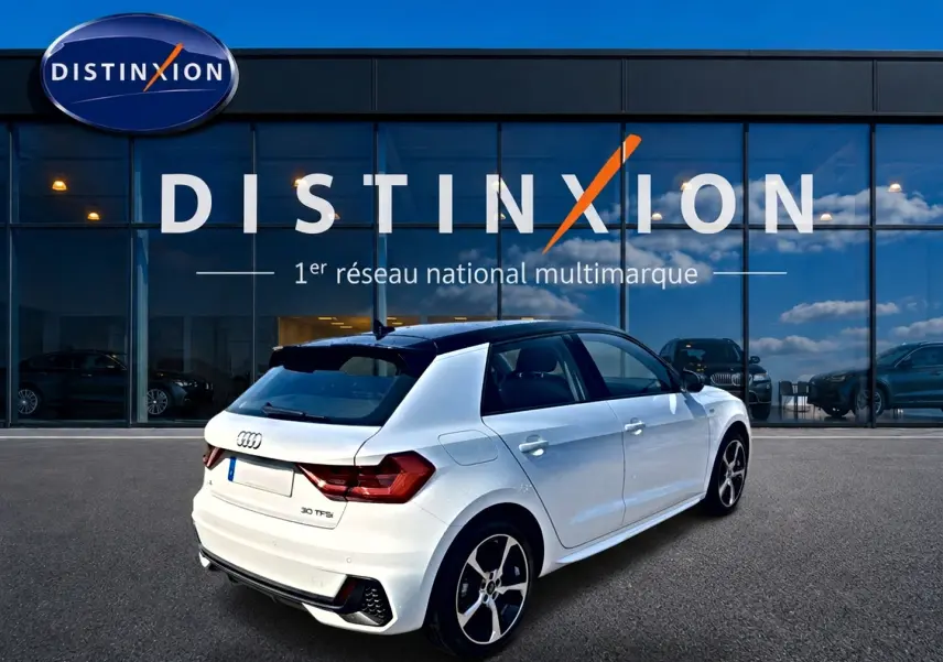Audi A1 Sportback blanc et noir vue 3/4 arrière droit avec jantes alu et toit contrasté noir devant vitrine Distinxion.