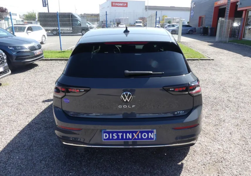 Vue arrière d'une Volkswagen Golf 1.5 eTSI grise métallisée avec vitres arrière surteintées et feux LED défilants.