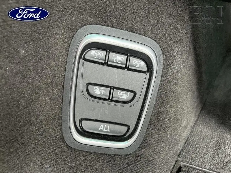 Panneau de commande noir avec boutons de réglage des sièges dans un intérieur sombre, sans lien visible avec Renault Espace.