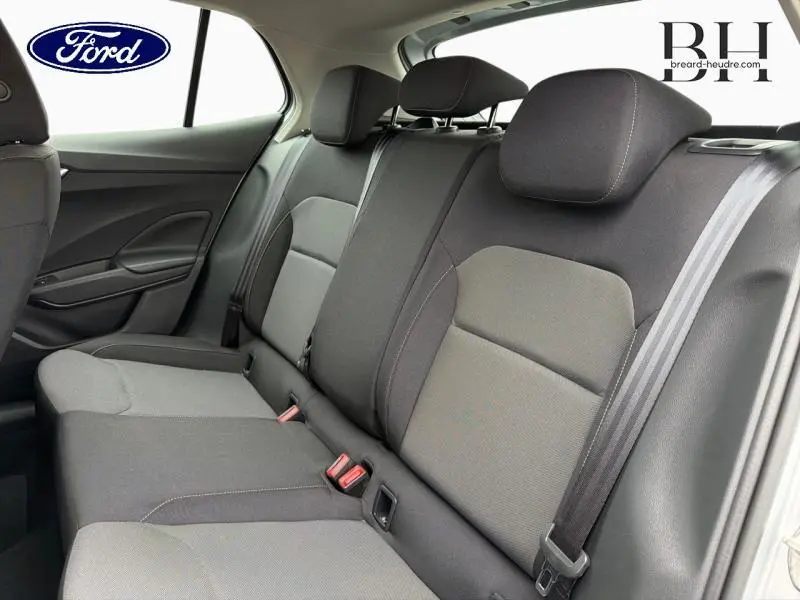 Vue intérieure arrière montrant la banquette grise avec appuie-têtes et ceintures de sécurité dans une Ford.