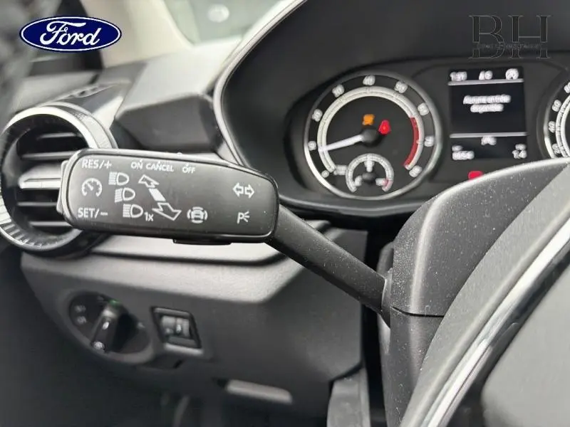 Gros plan sur la commande de régulateur de vitesse et tableau de bord noir d'une Skoda Fabia gris argent 2023.