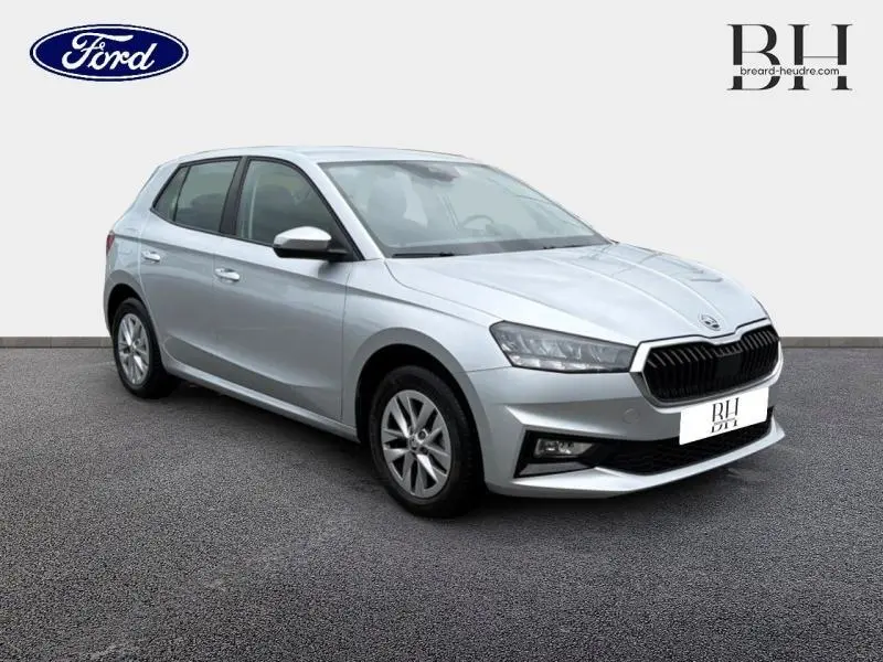 Vue 3/4 avant droite d'une Skoda Fabia 2023 gris argent métallisé avec calandre noire et jantes alu.