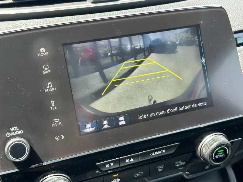 Écran tactile intérieur montrant la caméra de recul du Honda CR-V rouge Rallye, avec lignes de guidage jaunes.