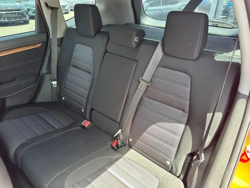 Vue intérieure côté arrière droit du Honda CR-V 2020 rouge Rallye, montrant la banquette noire avec appuis-tête et ceintures de sécurité.