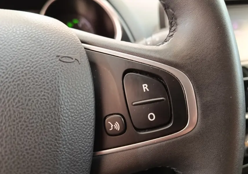 Gros plan sur le volant cuir noir de la Renault Clio Business dCi 75, avec commandes multifonctions visibles.