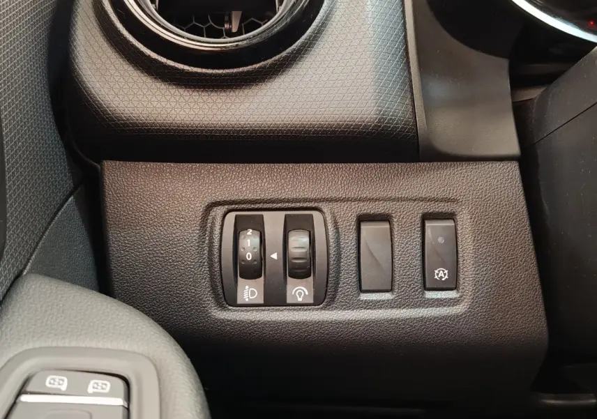 Gros plan sur les commandes de réglage des phares et fonction arrêt auto du moteur, tableau de bord noir Renault Clio 2018.