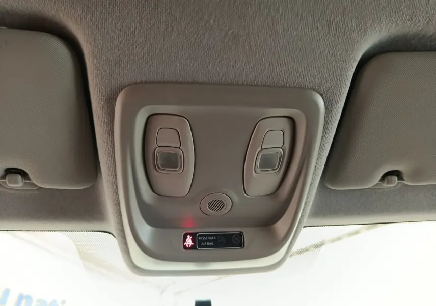 Plafonnier intérieur avec lampes de lecture et témoin airbag passager allumé dans Renault Clio Business blanc.