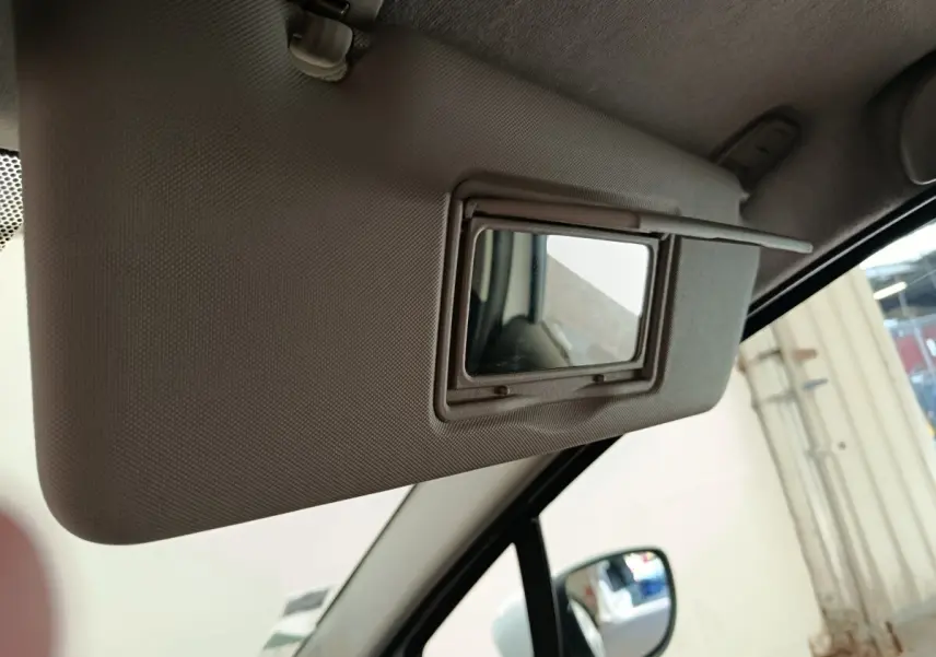 Miroir de courtoisie ouvert sur le pare-soleil côté conducteur d'une Renault Clio Business blanc, vue intérieure.