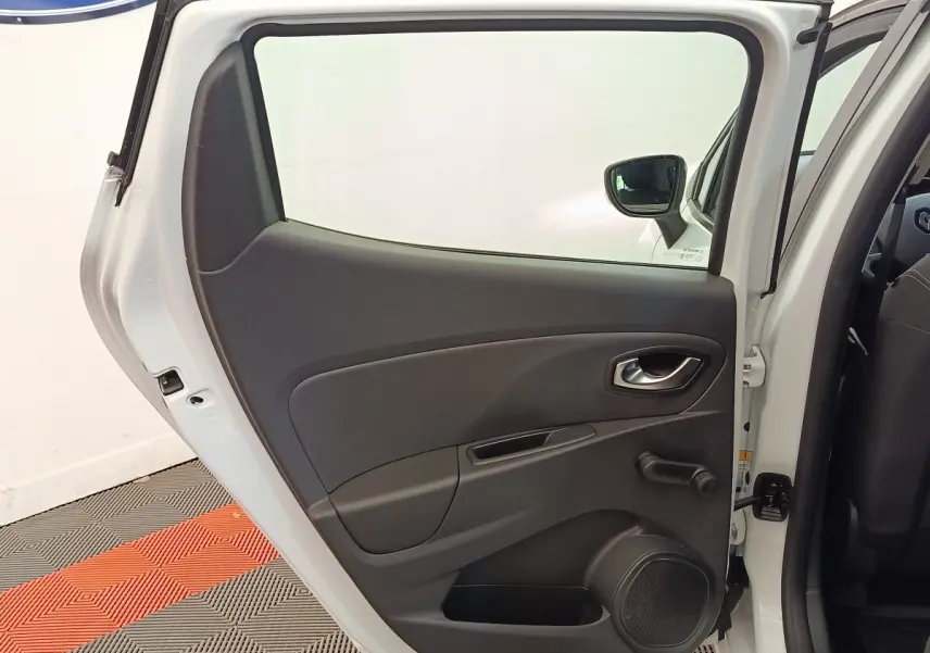 Vue intérieure de la porte arrière droite blanche d’une Renault Clio 2018 avec poignée et manivelle de vitre.