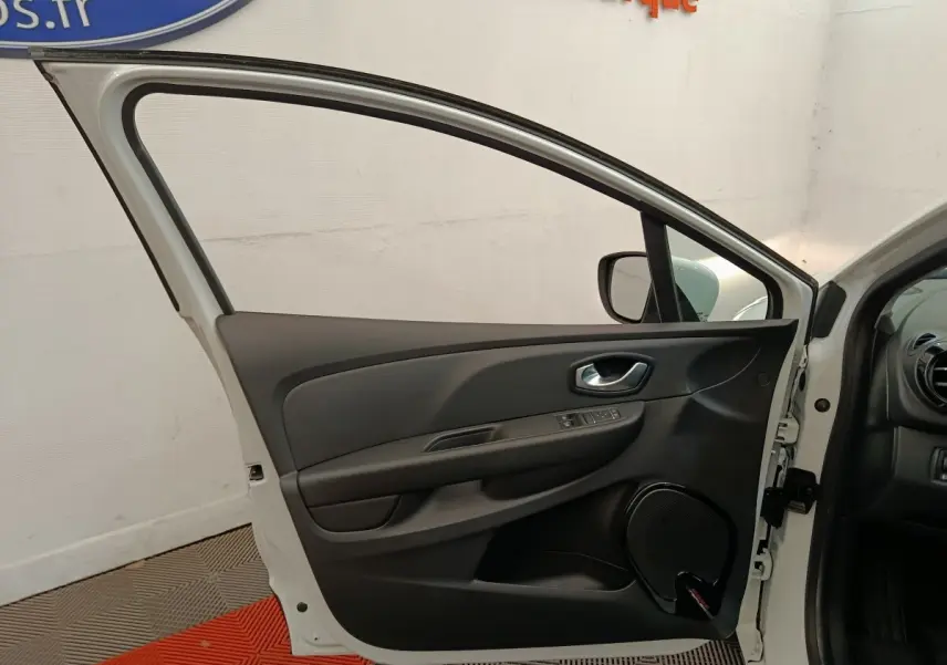 Vue côté gauche de la porte avant blanche ouverte d'une Renault Clio Business 2018, intérieur noir avec commandes électriques.