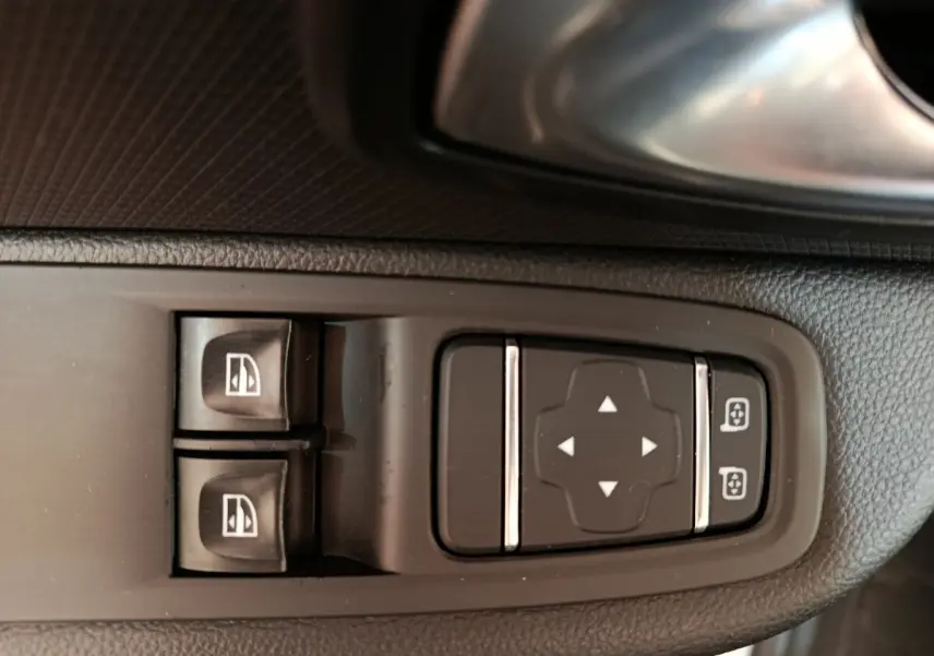 Gros plan sur les commandes de réglage des vitres et des rétroviseurs côté conducteur d’une Renault Clio Business blanc 2018.