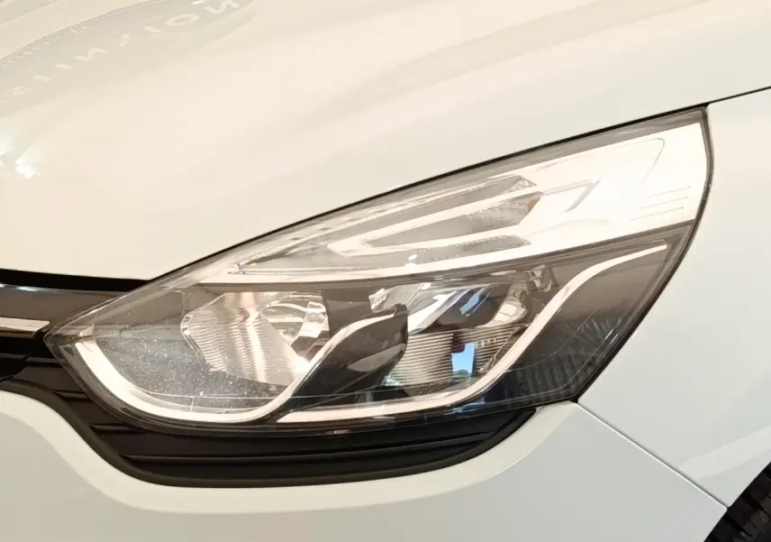 Gros plan sur le phare avant droit blanc d’une Renault Clio Business dCi 75 de 2018.