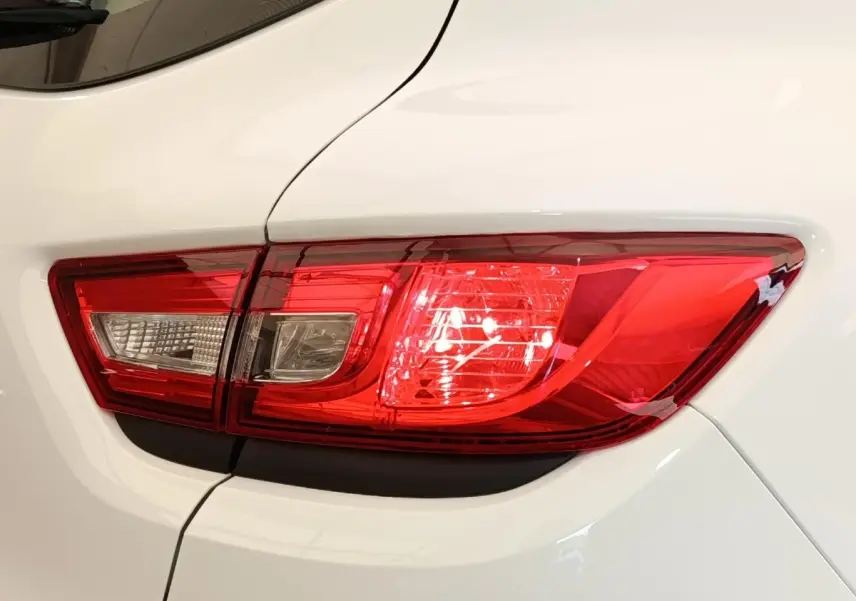 Gros plan sur le feu arrière droit rouge et blanc d’une Renault Clio Business dCi 75 blanche de 2018.