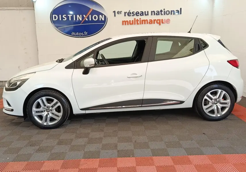 Profil côté gauche d'une Renault Clio Business dCi 75 blanche de 2018, avec jantes alliage et rétroviseurs blancs.