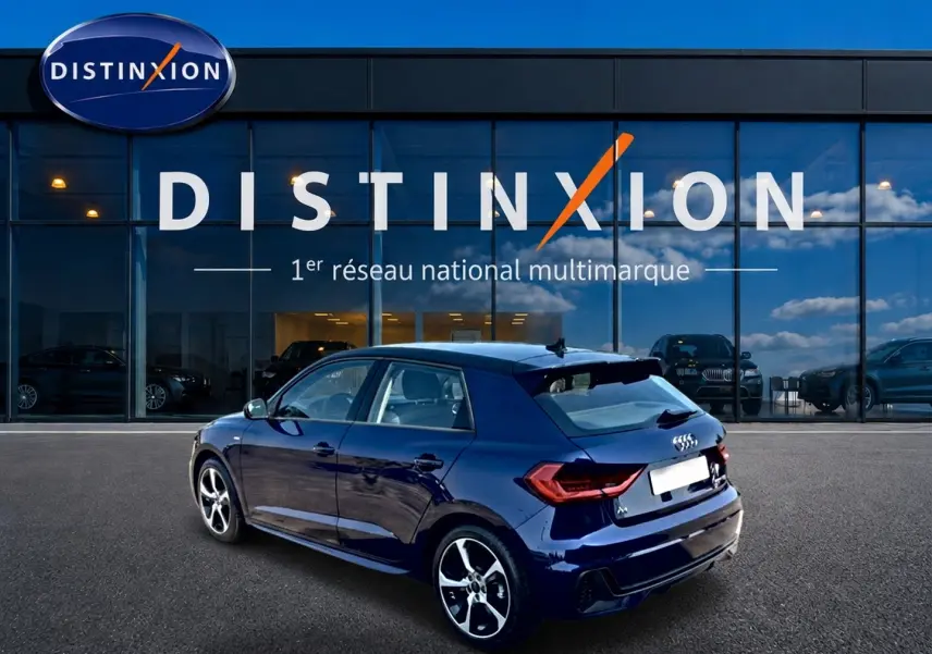 Audi A1 Sportback bleu foncé vue 3/4 arrière droit, avec jantes alliage et becquet arrière sportif.