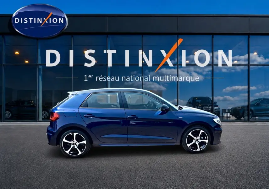 Audi A1 Sportback 30 TFSI S line bleu foncé vue de profil côté gauche devant une vitrine Distinxion.