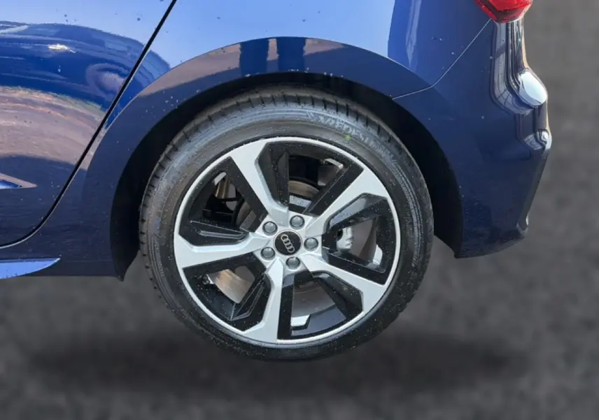 Gros plan sur la roue arrière droite et le passage de roue bleu foncé de l'Audi A1 Sportback 30 TFSI S line 2026.