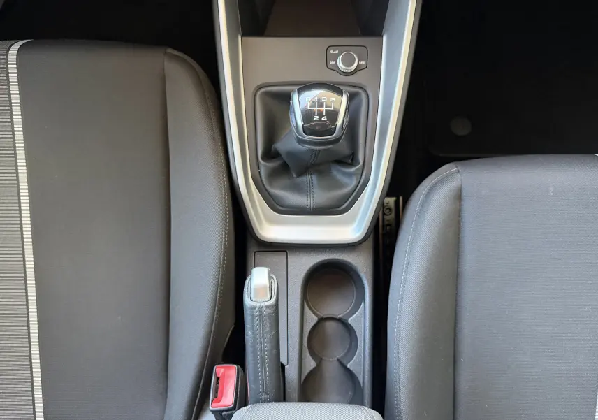 Vue plongeante sur la console centrale de l'Audi A1 Sportback 2020, avec levier de vitesse manuel et frein à main entre sièges noirs.
