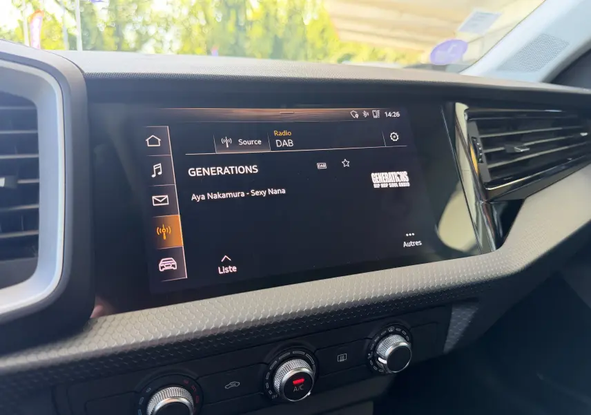 Vue rapprochée de l’écran central tactile de l’Audi A1 Sportback 2020, affichant la radio DAB sur fond noir.