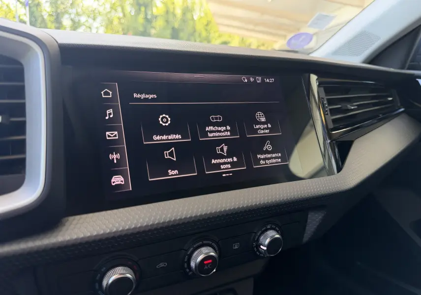 Vue rapprochée de l’écran tactile central et des commandes de climatisation dans l’habitacle d’une Audi A1 Sportback bleu firmament.