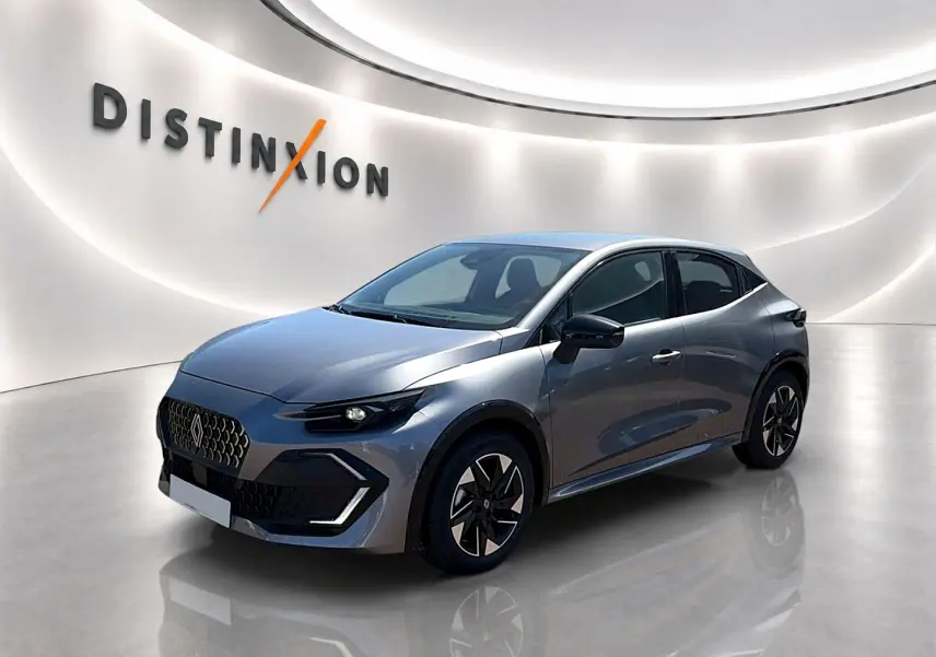 Vue 3/4 avant d'une Renault Clio VI gris schiste avec jantes alu et calandre distinctive dans un showroom lumineux.