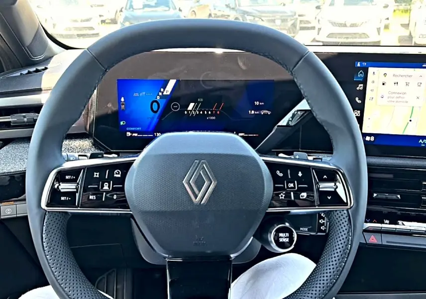 Vue intérieure frontale du volant noir de la Renault Clio VI avec écran numérique et tableau de bord moderne.