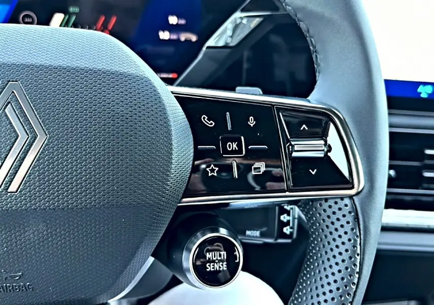 Gros plan sur la partie droite du volant gris de la Renault Clio VI avec commandes multifonctions et bouton Multi Sense.