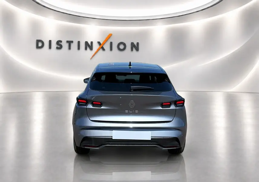 Vue arrière d'une Renault Clio VI gris schiste, avec feux arrière LED et becquet distinctif dans un showroom lumineux.