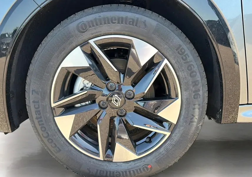 Gros plan sur la roue avant droite de la Renault Clio VI gris schiste avec jante alliage noire et argentée.
