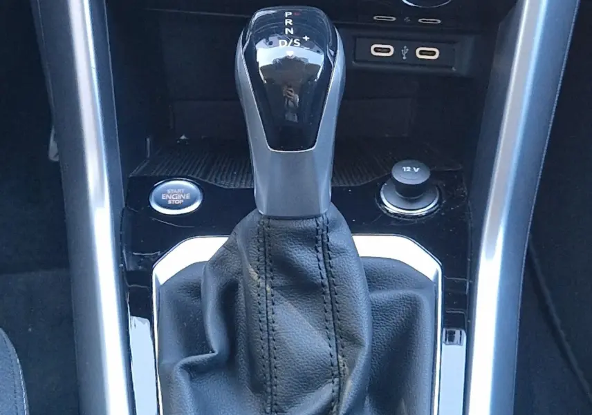 Le levier de vitesses automatique DSG7 du Volkswagen T-Roc 2023, entouré de commandes climatisation et bouton démarrage.