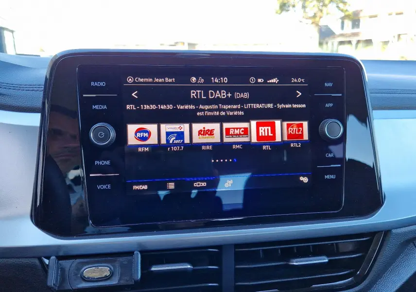 Écran tactile central du Volkswagen T-Roc gris pyrite 2023 affichant les radios DAB+ avec commandes autour.