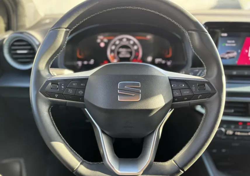 Volant sport cuir multifonction de la SEAT Arona TSI 115 Xpérience 2025, vue frontale centrée sur le logo SEAT.