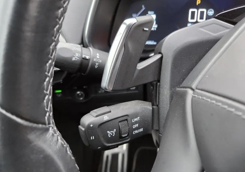 Gros plan sur les commandes au volant en cuir noir du DS7 Crossback 2022 avec palettes de changement de vitesse chrome.